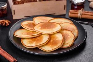 Delicious fresh pancakes on a wooden cutting board with sugar photo