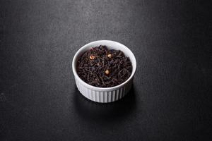 Black Ceylon tea - Top view of black tea background with green leaves photo