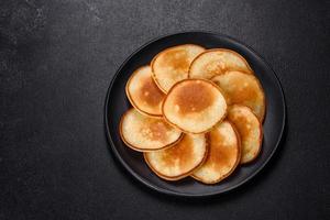 Delicious fresh pancakes on a wooden cutting board with sugar photo