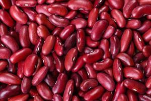 Beans of red dry raw beans on a dark concrete background photo