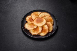 Delicious fresh pancakes on a wooden cutting board with sugar photo