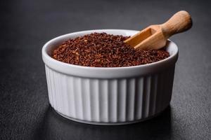 Rooibos tea on a black background. Flat lay, copy space photo