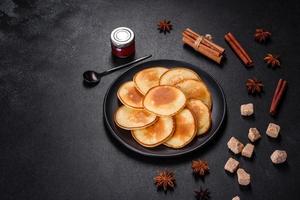 Delicious fresh pancakes on a wooden cutting board with sugar photo