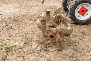 pequeño tractor agrícola ara el suelo, el trabajo de un tractor de empuje foto