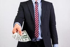 Businessman in suit holding several 100 dollar bills. Finance concept. photo