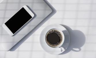 Sunlight and grid shadow pattern on surface of black coffee in white ceramic cup with blank smart phone and grey laptop on white tabletop photo