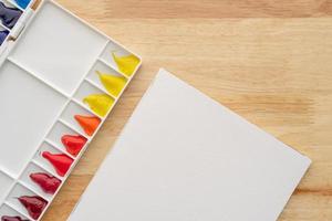 Abstract watercolor paints for background. White palette with white paper on wood. photo