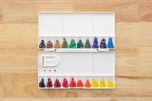 Colorful watercolor paints set in watercolor palette on wood. photo