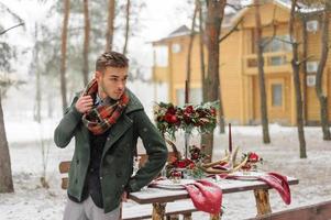 retrato de un novio barbudo en un elegante traje con tirantes y pajarita en invierno en una estación de esquí foto