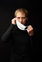 Portrait of a man, protection from Covid-19. a man wears a protective medical mask against viruses and infections. close up photo