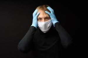 Protection against contagious disease, coronavirus. Man wearing hygienic mask to prevent infection 2019-nCoV. man's panic man puts on protective gloves photo