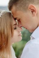 Photoshoot of a couple in love in the mountains. The girl is dressed like a bride in a wedding dress. photo