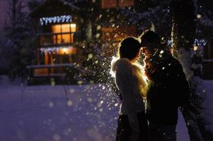 Beautiful bride and groom with a white dog are standing on the background of a snowy forest. photo