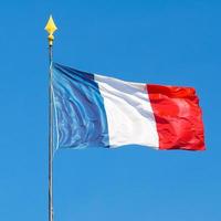 France tricolor flag waving into blue sky photo