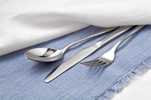 Spoon, fork and knife on blue tablecloth photo