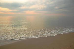 Beautiful sand beach background with soft wave in the morning. photo