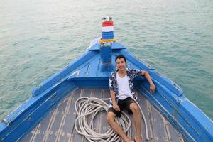 Man on wooden boat photo