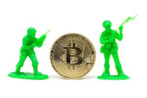 soldado en miniatura y bitcoin sobre fondo blanco foto