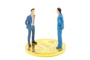 Miniature businessman and Bitcoin on white background photo