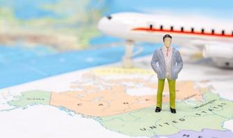 Miniature people, businessman standing on map American photo