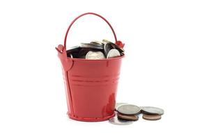 Small red bucket full of money on white background photo