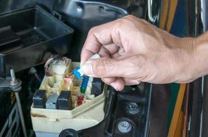 Mecánico de automóviles comprobando un fusible del coche foto