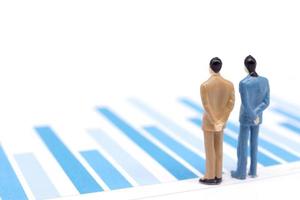 Miniature figures businessmen standing on a graph chart financial photo