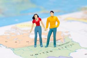 gente en miniatura, pareja de pie en el mapa americano foto