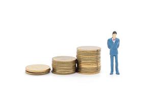 Toy businessman and coins on white background photo