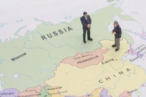 dos empresarios en miniatura shakehand en china y mapa ruso foto