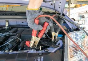 técnico automotriz cargando la batería del vehículo foto