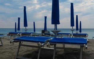 deckchairs on the sandy beach near the sea in July, in Spotorno on the western Ligurian Riviera