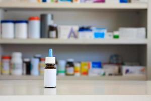 Medical Glass Brown Bottle With White Label, nasal drop medicine with blur drugstore shelves background photo