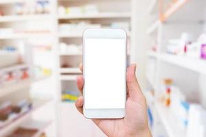 Woman using mobile smartphone in the pharmacy photo