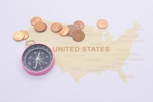 passport compass and coins on a American map. business travel concept