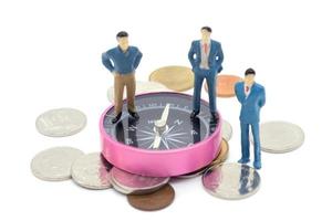 Miniature businessman and compass on coins stack on white background photo