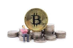 Toy businessman and Bitcoin on white background photo