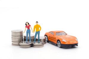 Miniature people,husband and wife standing with car and stack coins. saving and loan concept. photo