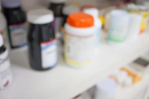 Bottles of pills arranged on shelf at drugstore photo