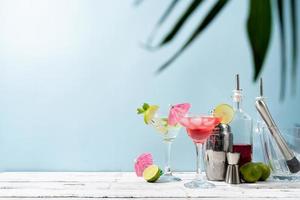 Fresh summer cocktails with strawberry, lime and ice cubes on blue background with copy space photo