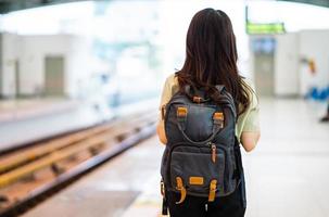 image of woman with backpack traveling at the train station photo