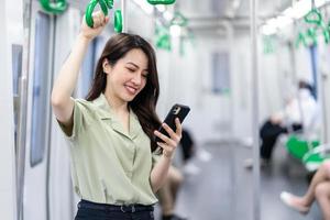 imagen de una mujer de negocios asiática usando un teléfono en el tren foto