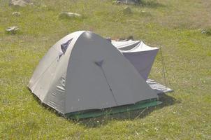 A fabric camping tent shelter in a field photo