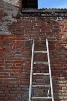 Ladder on an old red brick wall photo