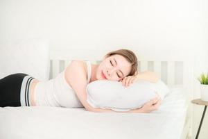 Young beautiful asian girl with long hair sleeping on white bed photo