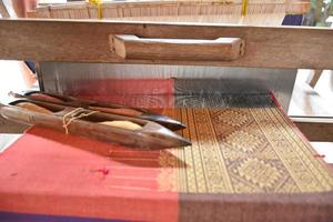 bobinas de tejido usadas con pequeños telares hechos de madera para tejer en hogares rurales tailandeses. foto