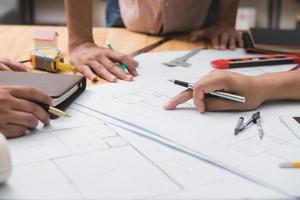 Team of architects or engineer discussing on desk with blueprint about new startup project on desk. Team group on construciton site check documents and business workflow.Selective focus. photo