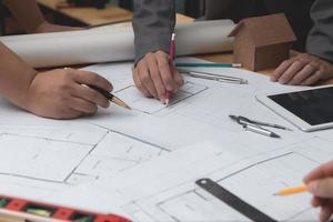 Hands of architect or engineer using pencil working with blueprint on desk in office . Engineering tools and construction concept. Architect and Business concept.Selective focus,Vintage effect. photo