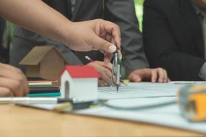 equipo de arquitectos o ingenieros discutiendo en el escritorio con planos sobre el nuevo proyecto de inicio en el escritorio. grupo de equipo en los documentos de verificación del sitio de construcción y el flujo de trabajo comercial. enfoque selectivo. foto