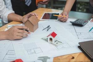 Team of architects or engineer discussing on desk with blueprint about new startup project on desk. Team group on construciton site check documents and business workflow.Selective focus. photo